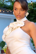 Close-up of a woman in a white satin gown with floral applique, showcasing the neckline detail.