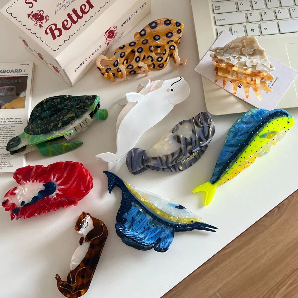 Assortment of novelty hair clips on a desk with a laptop and box