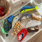 Various animal-shaped hair clips arranged on a tray with fruit and a candle