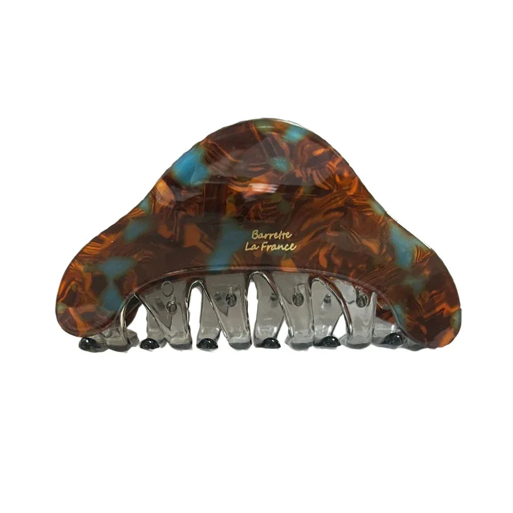Close-up of a tortoiseshell hair claw with blue and brown marbling. Main image