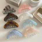 Several iridescent hair claws in different colors, including pink, blue, and white.