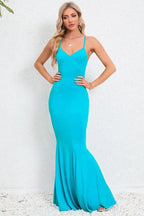 woman in a long turquoise mermaid dress with spaghetti straps and a v-neck