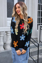 Woman wearing a black long-sleeve sweater with a colorful floral print, paired with a denim skirt.