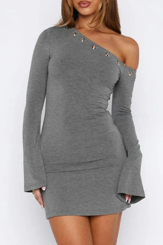 Side view of a woman in a grey one-shoulder dress with flared sleeves and grommet details.