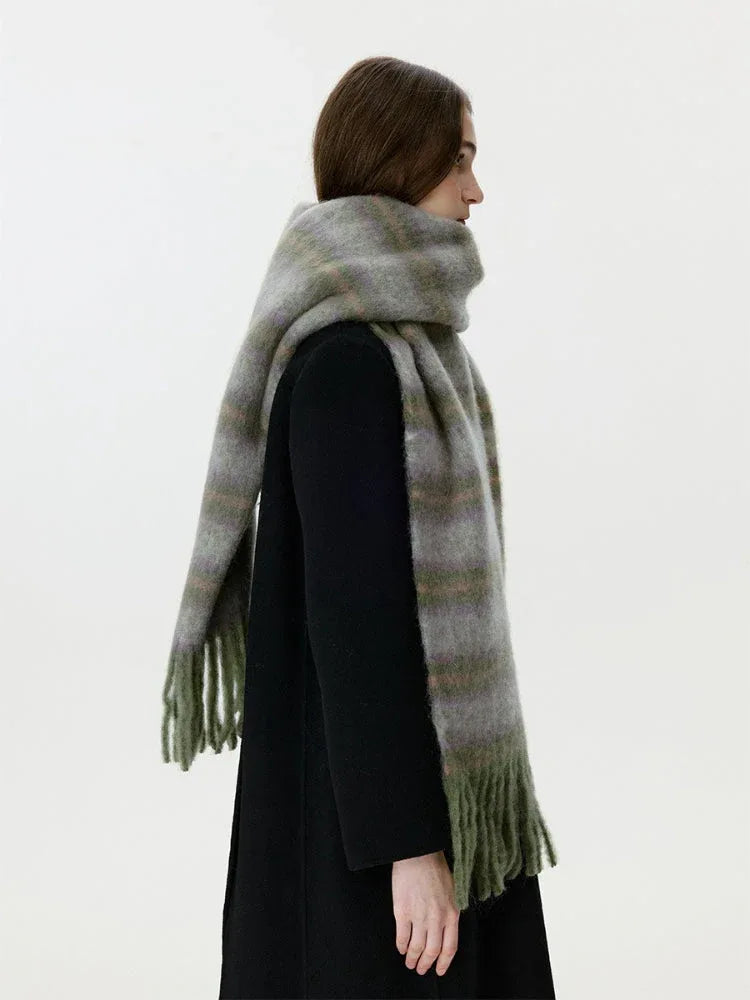 Woman in a black coat with a fuzzy, striped scarf wrapped around her neck, showing the fringe detail.