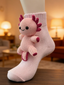 A pink knitted axolotl applique is attached to a light pink ribbed sock, showcasing its details.