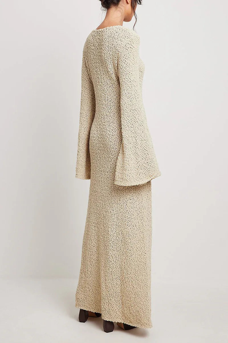 rear view of a woman wearing a cream textured knit maxi dress with long bell sleeves and a v-neckline
