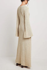 rear view of a woman wearing a cream textured knit maxi dress with long bell sleeves and a v-neckline