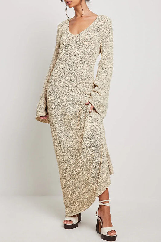woman wearing a cream textured knit maxi dress with long bell sleeves and a v-neckline, paired with platform sandals