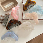 An assortment of colorful hair claws arranged on a white surface.