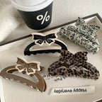 Close-up of brown and cream bow claw clip with other accessories
