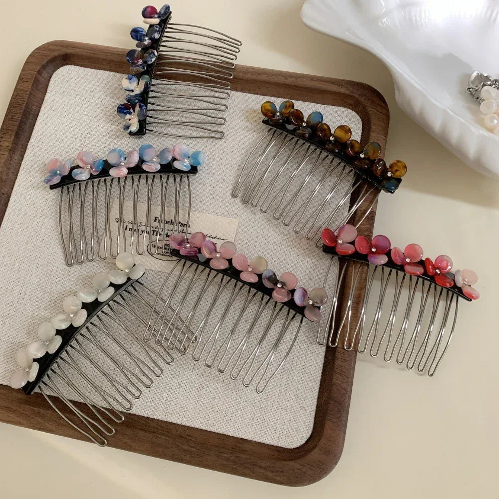 Assortment of decorative hair combs with colorful floral embellishments displayed on a wooden tray