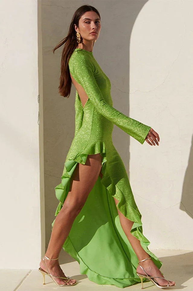 Woman wearing a lime green metallic knit dress with an asymmetrical ruffled hemline and an open back, shown in a side profile. Main image