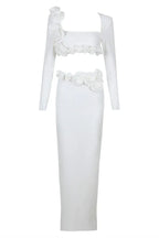 Studio shot of a white formal gown with a square neckline and long sleeves.