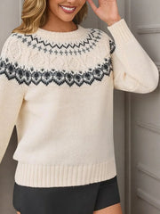 Woman wearing a cream-colored knit sweater with a Fair Isle pattern around the yoke, touching her hair.
