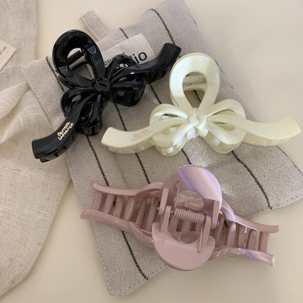 Three bow claw clips arranged on fabric