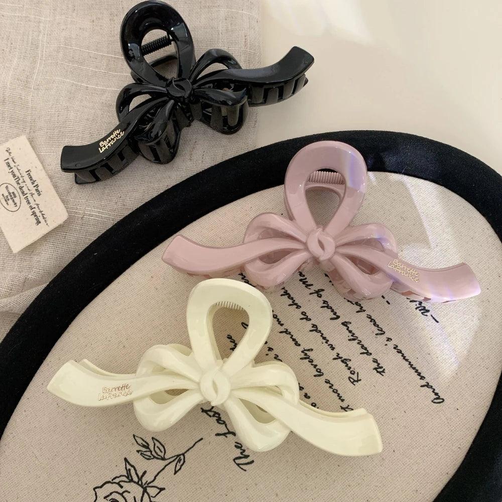 Collection of bow claw clips in black, pink, and white