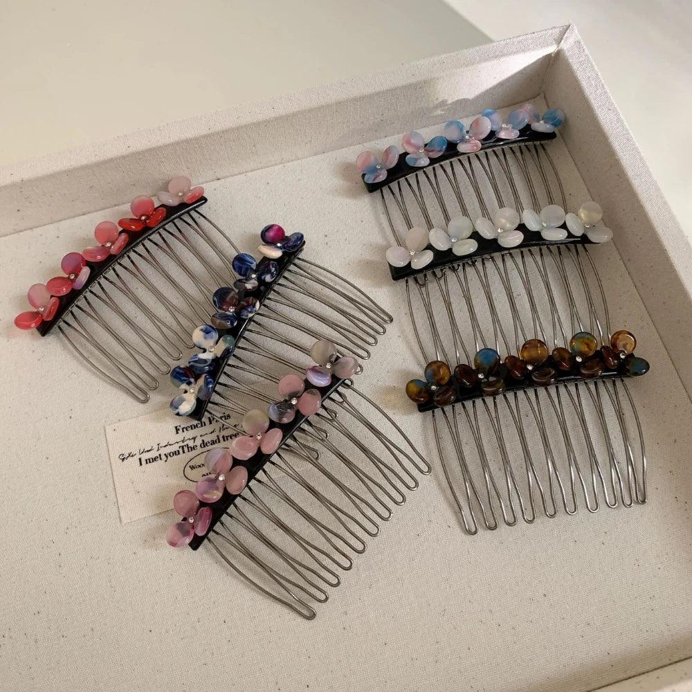 Several hair combs with flower-shaped beads arranged in a white tray