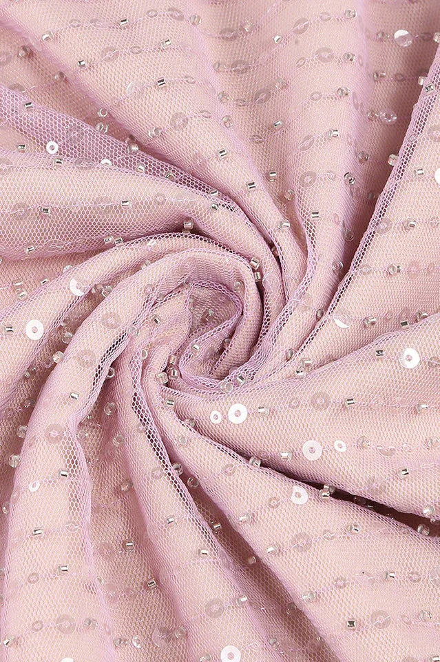 Close-up of the lavender sequined mesh fabric with sparkling embellishments.