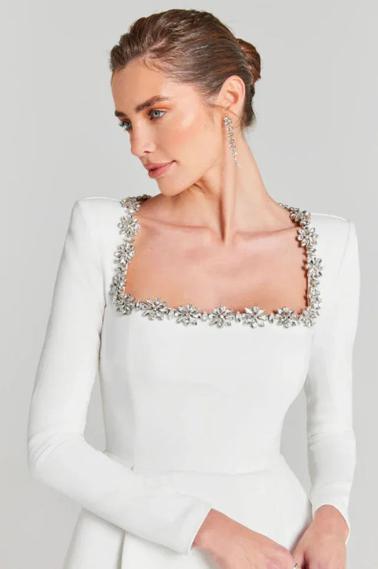 Close-up of the square neckline on a white dress featuring intricate floral beading.