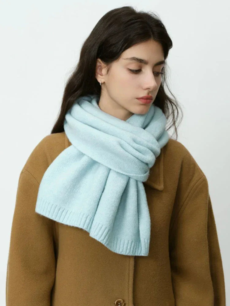 Profile view of a woman wearing a light blue scarf.