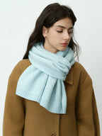 Profile view of a woman wearing a light blue scarf.