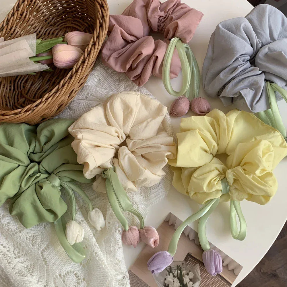 pastel scrunchies with tulip embellishments arranged with a basket and flowers