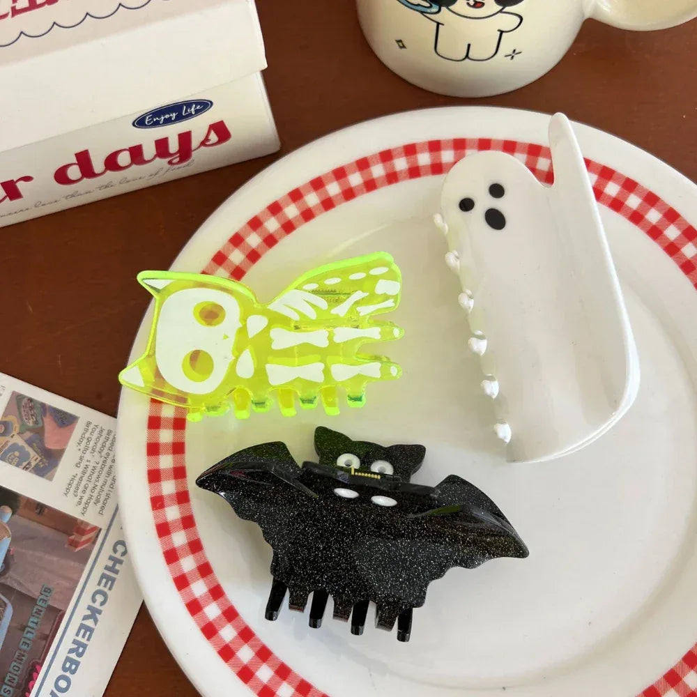 Halloween hair clips including a skeleton cat, ghost, and bat on a plate with a red and white checkered rim
