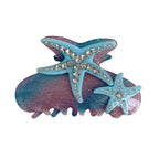 Blue and pink glitter hair claw clip with two starfish embellishments adorned with rhinestones.