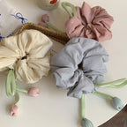 pastel scrunchies with tulip embellishments on a white table