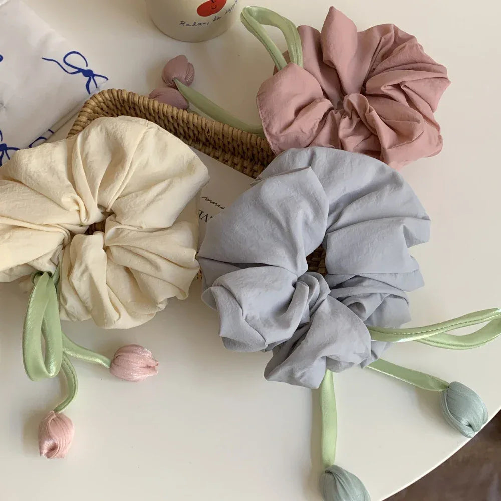 pastel scrunchies with tulip embellishments on a white table