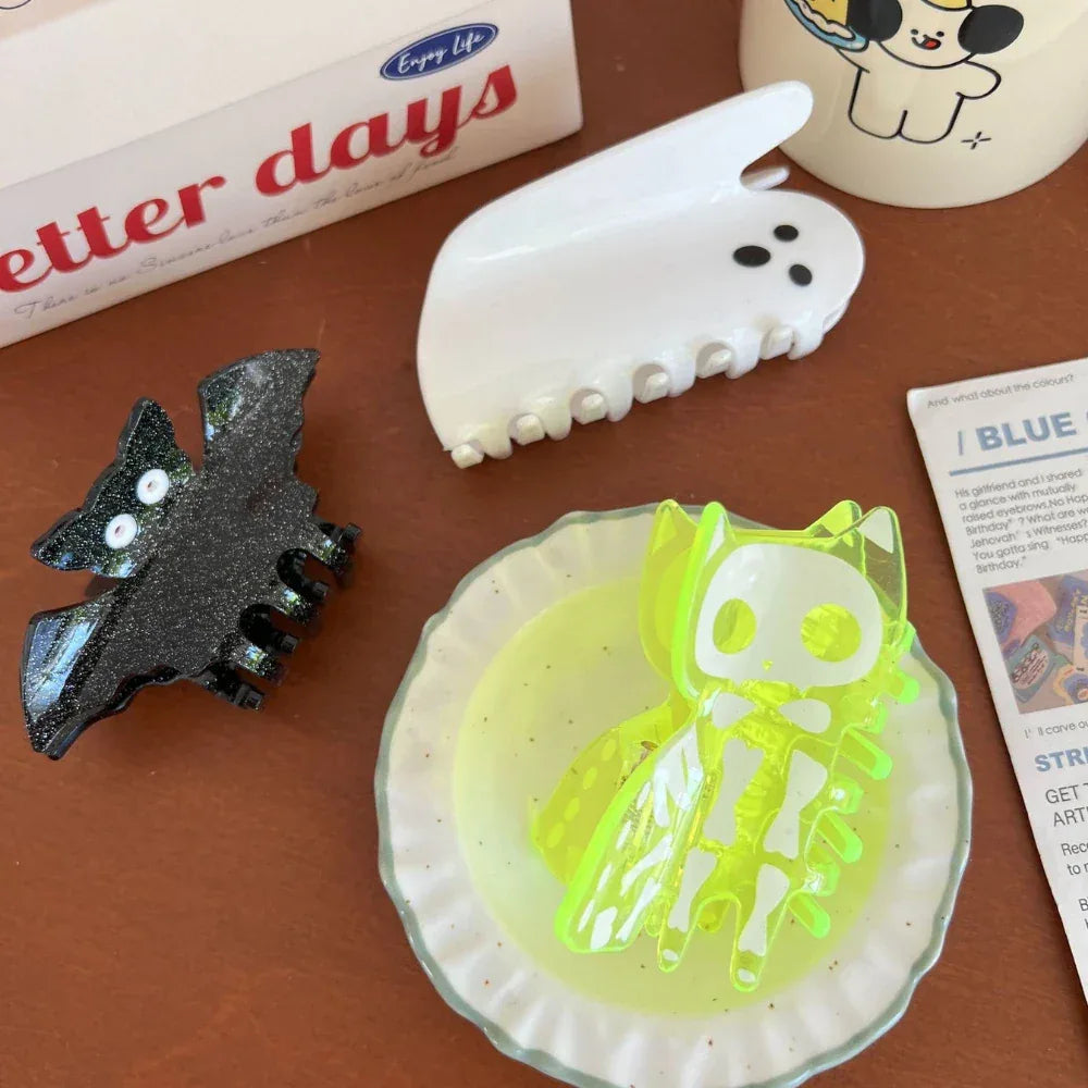 Close-up of Halloween hair clips: skeleton cat, ghost, and bat