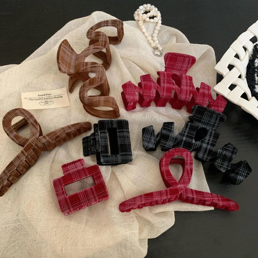 Assortment of plaid velvet hair accessories arranged on a cloth and book