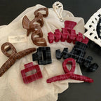 Assortment of plaid velvet hair accessories arranged on a cloth and book