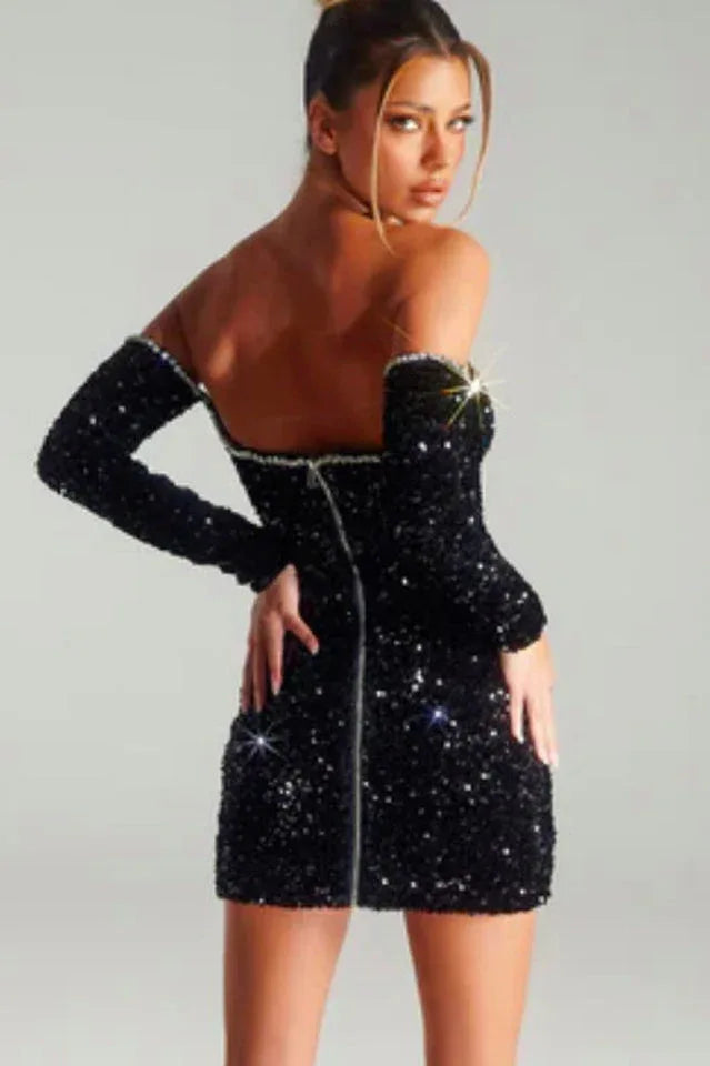 Back view of a woman in a black sequined off-the-shoulder mini dress with long sleeves.