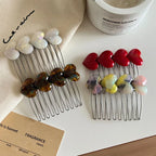 Collection of heart-shaped hair combs displayed on a white surface
