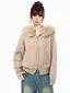 Woman wearing a beige knit cardigan with a faux fur collar and blue jeans, front view