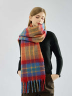 Woman with hands in pockets wearing a multi-colored plaid scarf