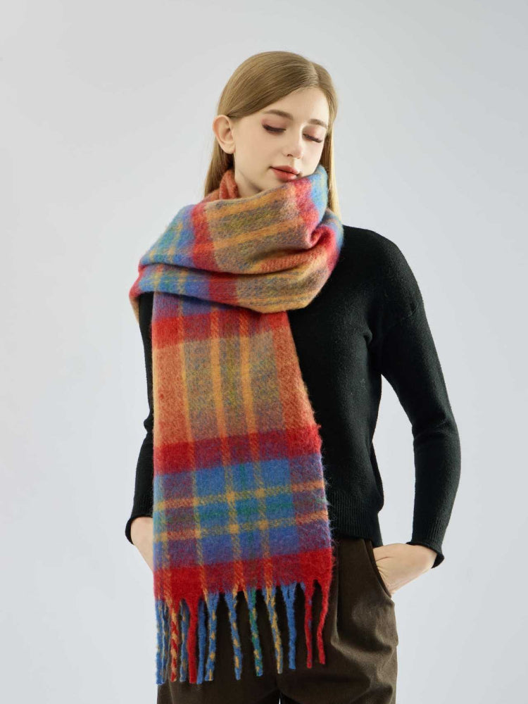 Woman with hands in pockets wearing a multi-colored plaid scarf
