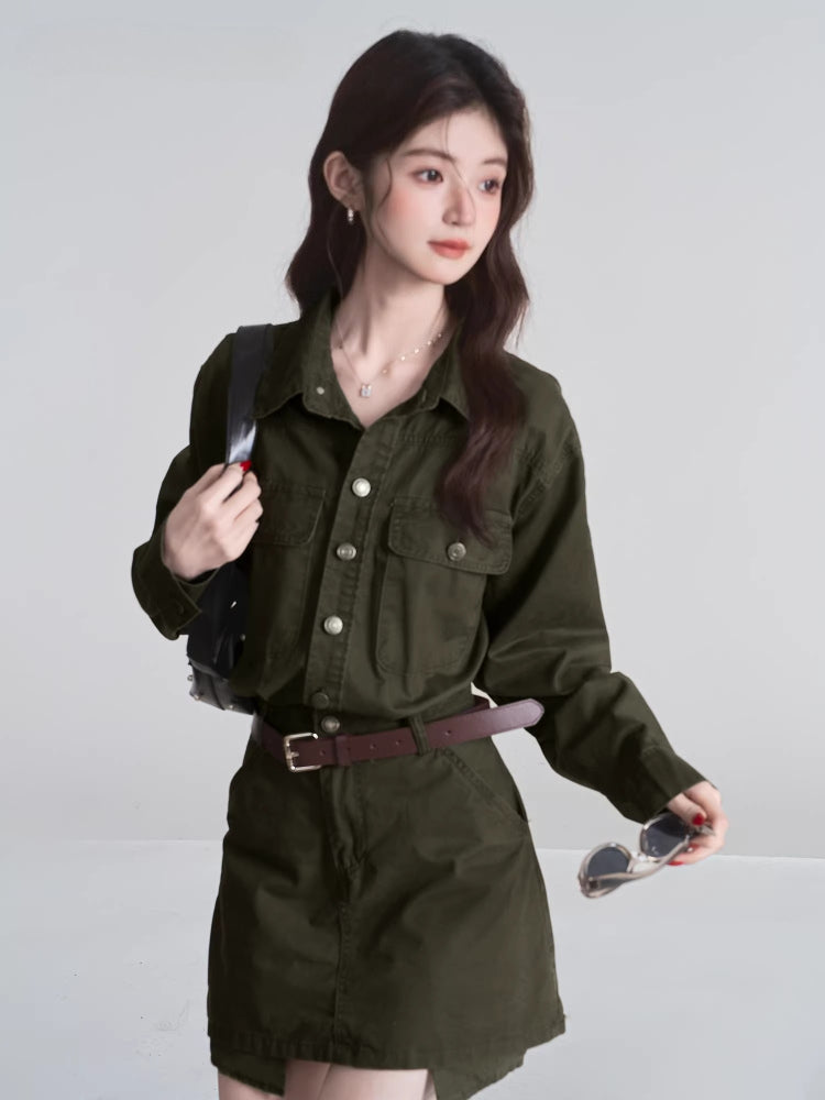 Woman in a green shirt and skirt set, holding a black handbag and sunglasses