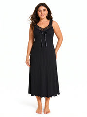 Woman wearing a black ribbed knit nightgown with lace trim and a bow