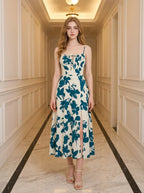 Woman wearing a floral print midi dress with spaghetti straps and a tie front detail, standing in a hallway.