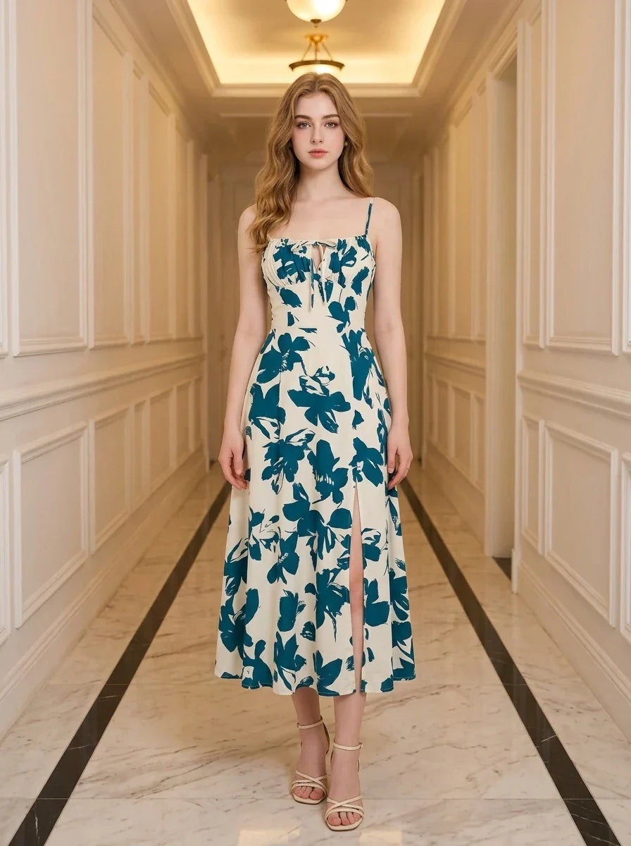 Woman wearing a floral print midi dress with spaghetti straps and a tie front detail, standing in a hallway.