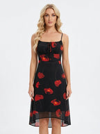 Woman wearing a black sleeveless midi dress with a red floral print and spaghetti straps.