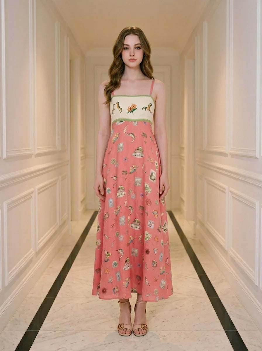 Woman in a coral A-line midi dress with spaghetti straps and a square neckline, standing in a hallway.