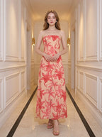 Woman standing in a hallway wearing a strapless floral print midi dress.