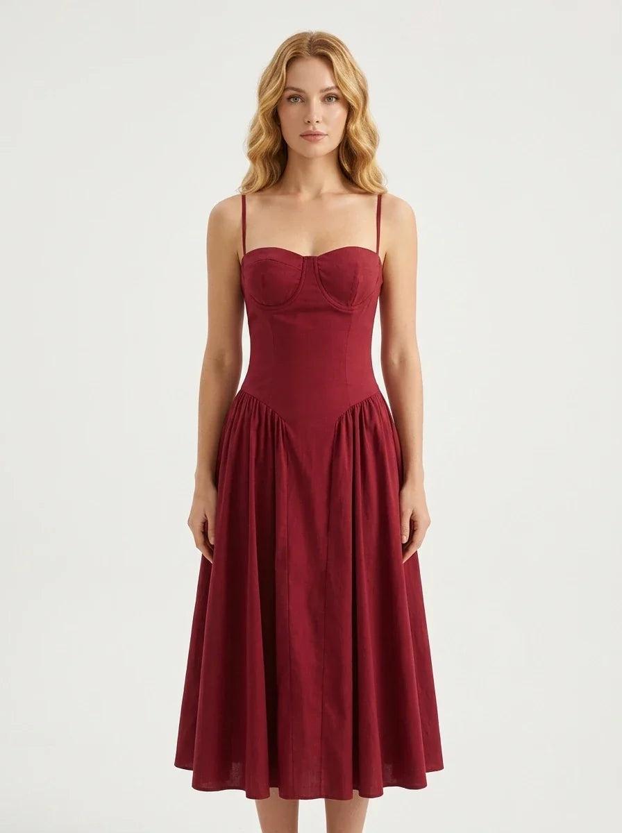 Woman wearing a deep red fit and flare midi dress with spaghetti straps, front view