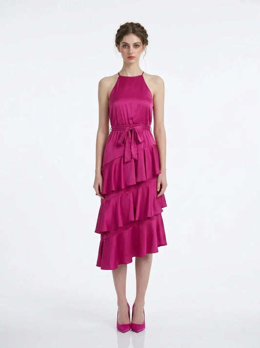 Woman wearing a fuchsia satin halter tiered midi dress with a self-tie belt.