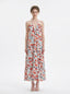 Woman wearing a white floral print maxi dress with a halter neckline and tiered skirt, standing against a white background.