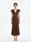 Woman wearing a brown polka dot midi dress with ruffled sleeves and a v-neckline, standing against a white background.